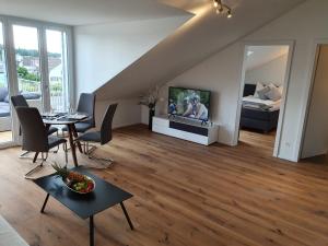 a living room with a dining table and a tv at Wohnstation in Subingen