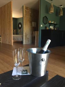 a bottle of champagne in a bucket next to two glasses at L ABRI spa et détente in Liergues