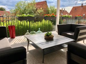 eine Terrasse mit einem Tisch, Stühlen und einem Zaun in der Unterkunft Maison d hotes Coeur de Village Alsace & spa in Rohrwiller