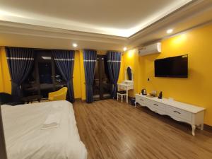 Una habitación de hotel con una cama y un televisor de pantalla plana. en Bonjour Sa Pa Hotel, en Sa Pa