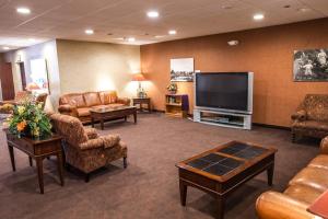 a waiting room with leather furniture and a flat screen tv at Sophie Station Suites in Fairbanks