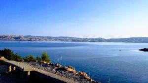 a bench sitting on the side of a body of water at Villa Mihaela - Apartment Ika in Cesarica