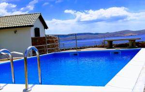 a blue swimming pool with a view of the water at Villa Mihaela - Apartment Mario in Cesarica