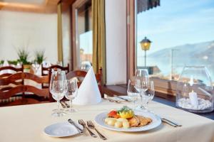 una mesa con un plato de comida y copas de vino en Hotel Kreuz, en Leissigen