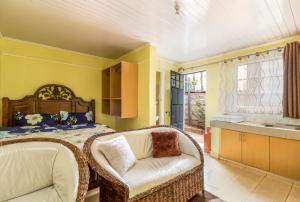 a bedroom with a bed and a wicker chair at AnD Suites in Nairobi