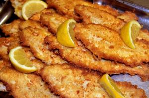 a pile of fried food with lemon slices on it at Hotel-Restaurant England in Nordstrand