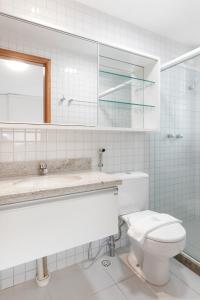 a bathroom with a toilet and a sink and a mirror at Condomínio Nui Supreme (BY MAI) in Porto De Galinhas