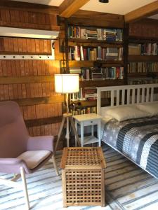 a bedroom with a bed and a chair and bookshelves at Skay Loft in Braşov