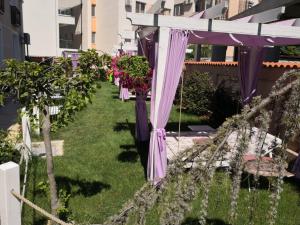 a garden with purple umbrellas and flowers at Vila Kataleya Mamaia Nord in Mamaia Sat/Năvodari