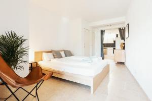 1 dormitorio blanco con 1 cama y 1 silla en Lake Villa Lotus en Luzern