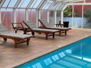 a conservatory with chairs and a swimming pool at Apartamentos Isla Encantada in Puntallana