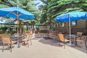 a patio with tables and chairs and a fire place at Falcon Point in Avon