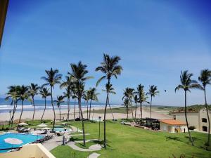 a beach with palm trees and palm trees at Las Villas Hotel & Golf By Estrella del Mar in Mazatlán