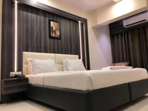 a bedroom with a large bed with a large window at Hotel Avon Ruby Dadar in Mumbai