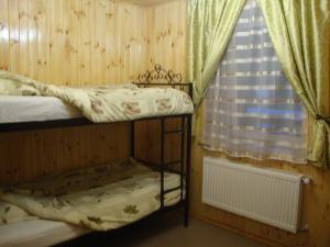 een kleine kamer met 2 stapelbedden en een raam bij Сердце Каньона in Kamjanets-Podilsky
