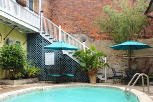 basen ze stołami i parasolami obok budynku w obiekcie Hotel St. Pierre French Quarter w Nowym Orleanie