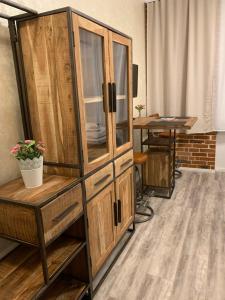 a wooden cabinet in a room with a table at Haus 8 in Lübeck