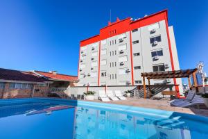 a hotel with a swimming pool in front of a building at Hotel Suárez Campo Bom in Campo Bom