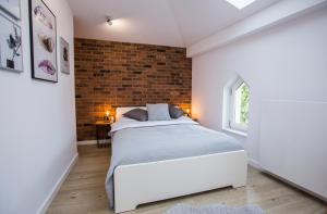 um quarto com uma cama e uma parede de tijolos em Grodzka6 em Bydgoszcz