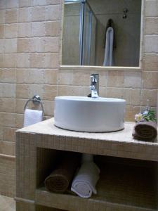 a bathroom with a sink and a mirror and towels at Apartamentos San Gregorio in Alquézar