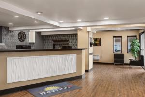 an office lobby with a reception counter and a fireplace at Days Inn & Suites by Wyndham Sault Ste. Marie ON in Sault Ste. Marie