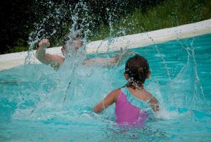 a boy and a girl playing in a swimming pool at Piccola Valle in Vobarno