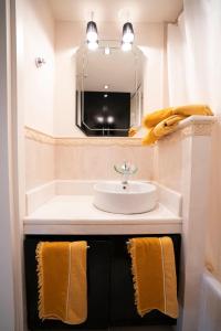 a bathroom with a sink and a mirror and towels at Marousi Luxury Apartment in Athens