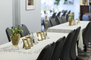 a row of tables with chairs and flowers on them at Rezydencja Legrams in Darłowo +64 photos