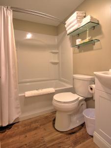 a bathroom with a toilet and a tub and a shower at Studio East Motel in Ogunquit