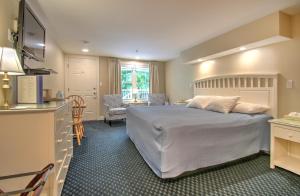 a bedroom with a large bed and a kitchen at Studio East Motel in Ogunquit
