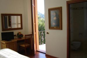 1 dormitorio con puerta que da a un balcón con escritorio en Hotel La Rosa, en Ronta