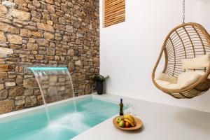 a bathtub with a bowl of fruit and a bottle of wine at Obsession Mykonos in Agios Stefanos