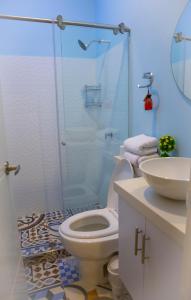 庫庫塔的住宿－Casana Hotel，一间带卫生间和玻璃淋浴间的浴室