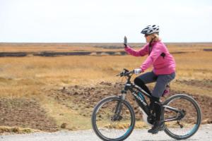 Eine Frau fährt mit dem Fahrrad auf einer Straße in der Unterkunft Intiqa Hotel in Puno