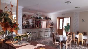a dining room with a table and a bar at PENZION EUROPA Diakovce in Diakovce +29 photos