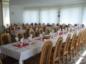 een lange tafel in een kamer met veel stoelen bij PENZION EUROPA Diakovce in Diakovce