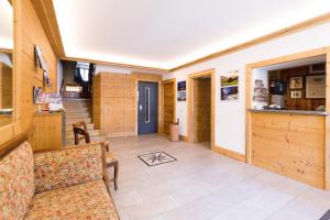 uma sala de estar com paredes de madeira e piso em azulejo em Meublé Albergo Dante em Bormio