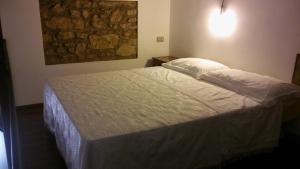 a bed in a bedroom with a stone wall at Dammuso Ludovico in Ragusa