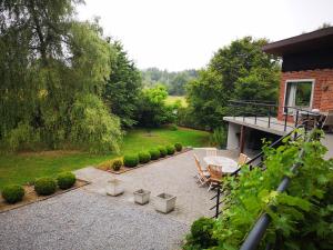 a patio with a table and chairs and a house at Au Bord De L'eau in Durbuy