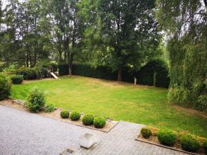 einen großen Garten mit einem Rasen mit Büschen und Bäumen in der Unterkunft Au Bord De L'eau in Durbuy