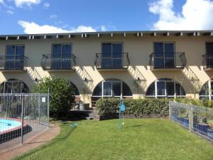 un immeuble d'appartements avec une piscine et un terrain de basket-ball dans l'établissement 299 On Devon West, à New Plymouth