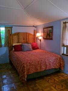 a bedroom with a large bed with a red blanket at 1 Beige Cozy Bungalow or 1 White Cozy Efficiency Cottage in Titusville in Titusville