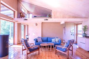 - un salon avec un canapé bleu et des chaises dans l'établissement Studio Zempow, ökologisches Ferienhaus, à Zempow