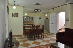 uma cozinha e sala de estar com mesa e cadeiras em White Villa em Luxor