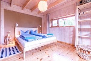 a bedroom with a bed with blue pillows on it at Studio Zempow, ökologisches Ferienhaus in Zempow