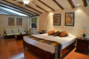 a bedroom with a large bed and a couch at Hacienda Chichen Resort and Yaxkin Spa in Chichén-Itzá