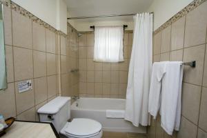 ein Badezimmer mit Badewanne, Toilette und Waschbecken in der Unterkunft Jan's Hotel in Caye Caulker