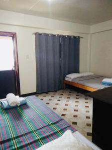 a room with two beds and a blue curtain at Mayoyao View Inn in Banaue
