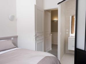 a white bedroom with a bed and a bathroom at Sasha bel appartement renove centre ville Beaune in Beaune