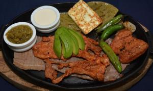 un plato de comida con carne y verduras en una mesa en Hotel Magico Inn, en Cuautla Morelos